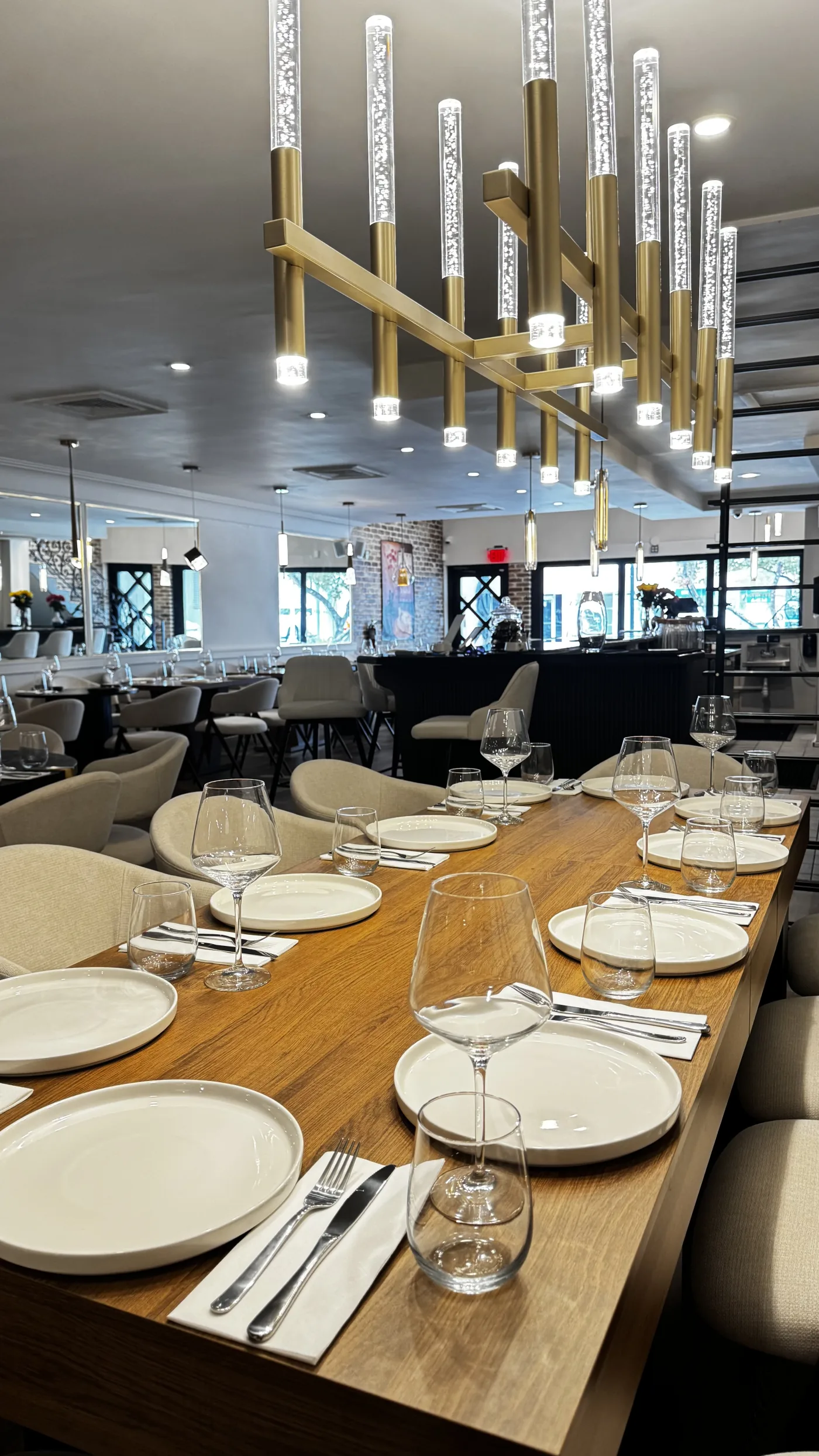 Inside BEKA — long table set with crystal stemware, brass lanterns