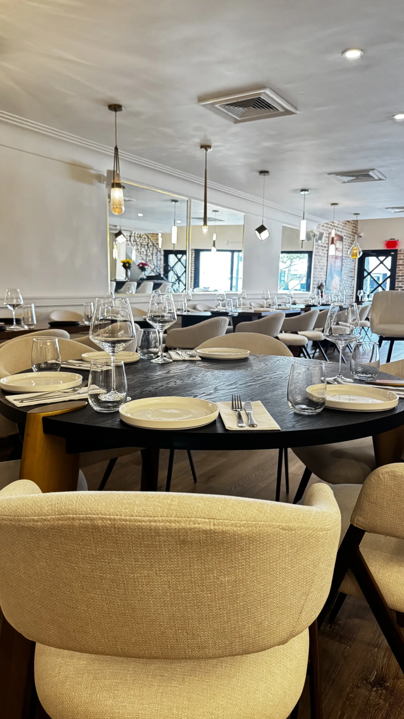 BEKA dining room from the front — cream chairs and brass lanterns